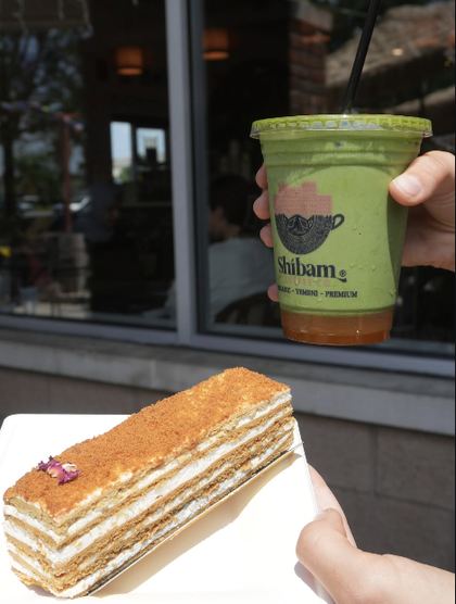 Honey cake slice and iced matcha outside Shibam Coffee Co.