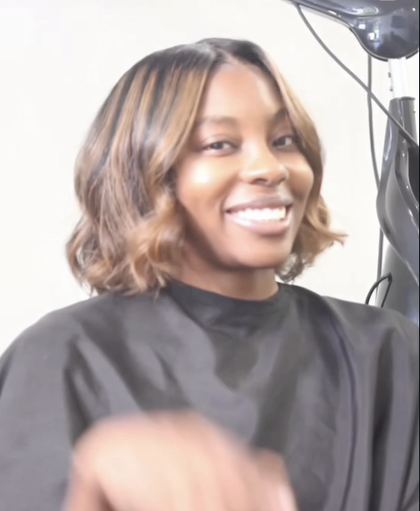 Reel still: client smiling after a curled bob with honey highlights