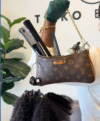 Reel still: gloved hand holding a designer bag packed with hair tools