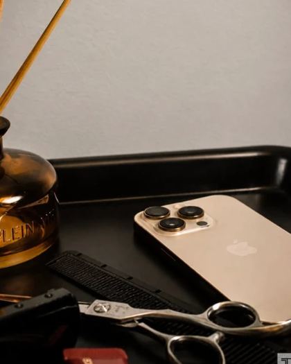 Carousel slide: styling tray with scissors, comb and a phone beside a reed diffuser